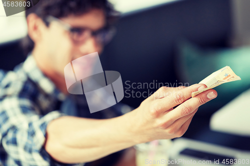 Image of happy man with cash money paying at cafe