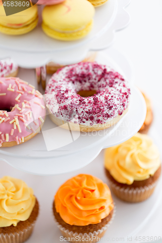 Image of close up of glazed donuts and cupcakes on stand