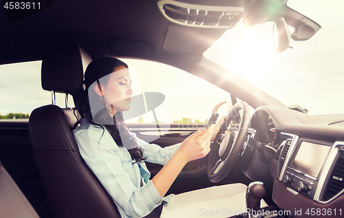 Image of woman driving car with smarhphone