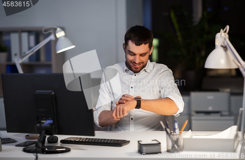 Image of happy businessman with smart watch at nigh office