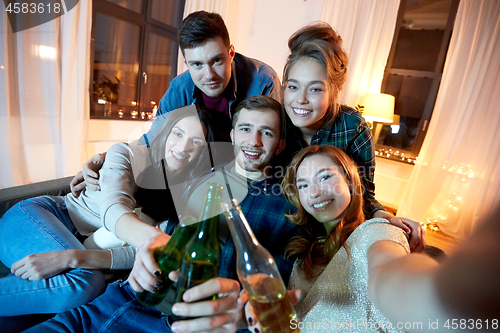 Image of happy friends taking selfie at home party