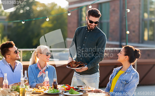 Image of friends at bbq party on rooftop in summer