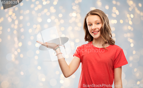 Image of smiling teenage girl holding empty hand