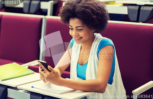 Image of african student girl with smartphone on lecture