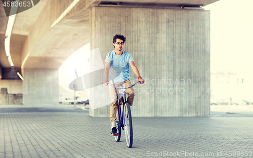 Image of young hipster man riding fixed gear bike