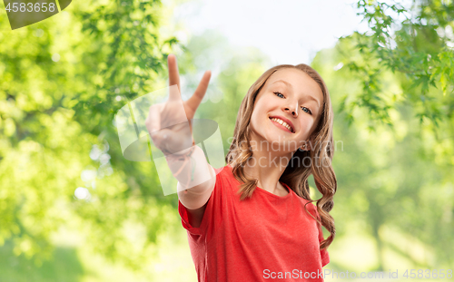 Image of smiling teenage girl in red t-shirt showing peace