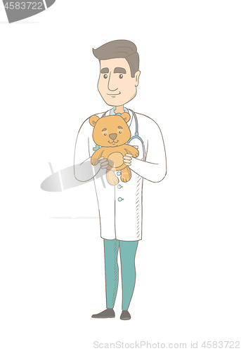 Image of Young caucasian pediatrician holding teddy bear.