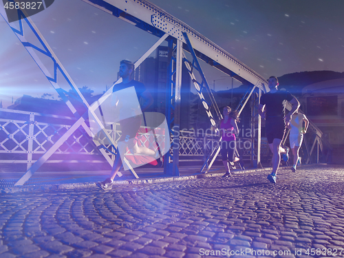 Image of young people jogging across the bridge