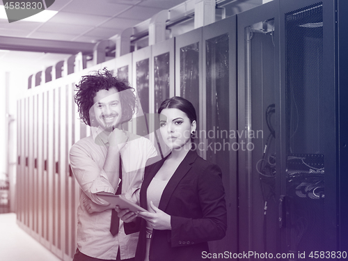 Image of engineer showing working data center server room to female chief