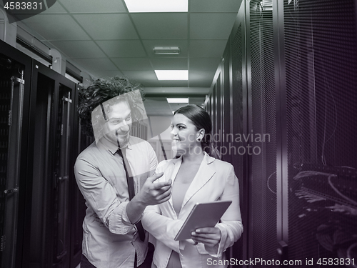 Image of engineer showing working data center server room to female chief