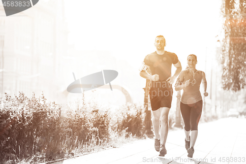 Image of young couple jogging  in the city