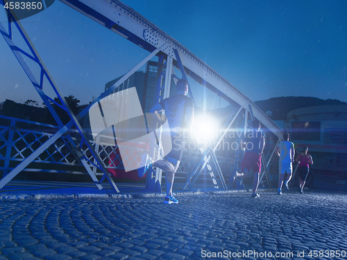 Image of young people jogging across the bridge