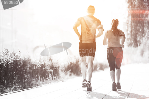 Image of young couple jogging  in the city