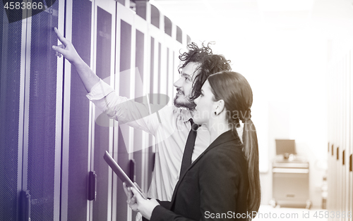 Image of engineer showing working data center server room to female chief