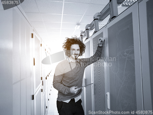 Image of IT engineer working on a tablet computer in server room