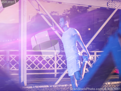 Image of man jogging across the bridge in the city