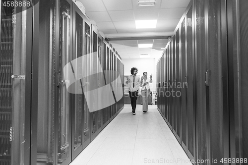 Image of engineer showing working data center server room to female chief