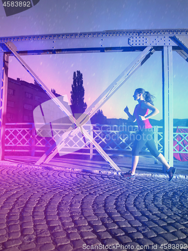 Image of man jogging across the bridge in the city