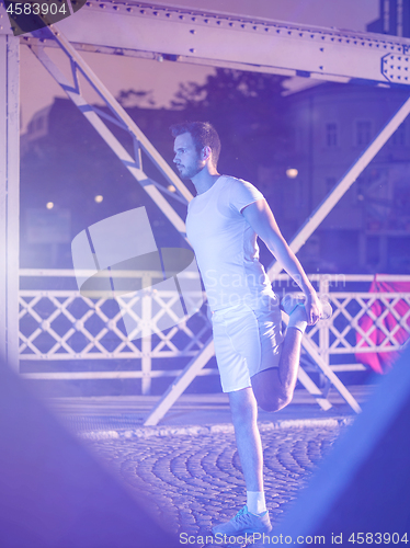 Image of man jogging across the bridge in the city