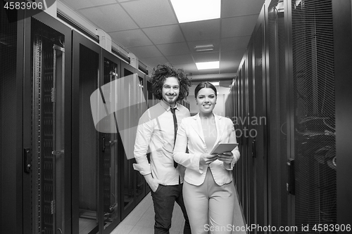 Image of engineer showing working data center server room to female chief