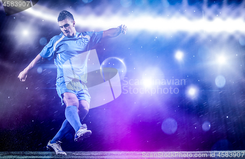 Image of soccer player in front of big modern stadium with flares and lig