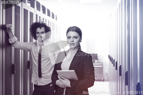 Image of engineer showing working data center server room to female chief