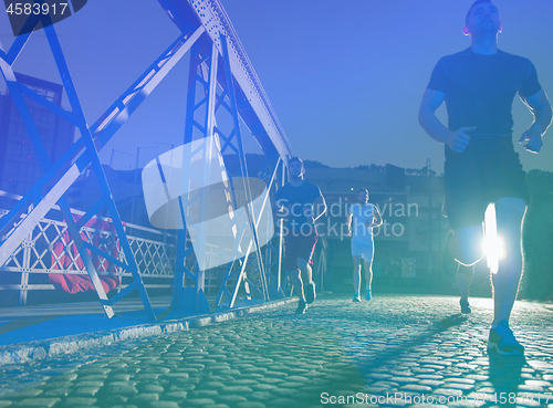 Image of young people jogging across the bridge