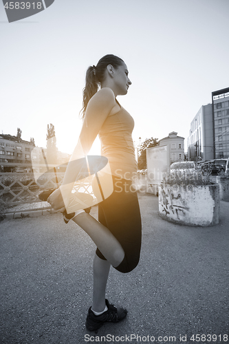 Image of woman jogging across the bridge at sunny morning