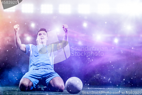 Image of soccer player in front of big modern stadium with flares and lig