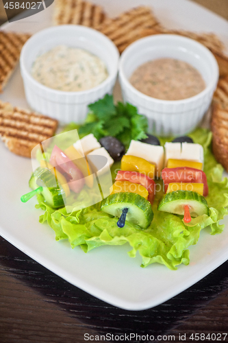 Image of toast with cheese vegetables and olive on the stick