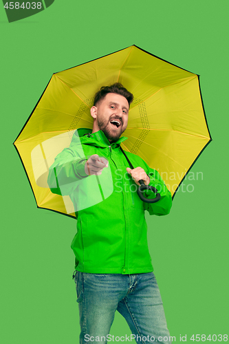 Image of handsome bearded young man holding umbrella and looking at camera isolated on white
