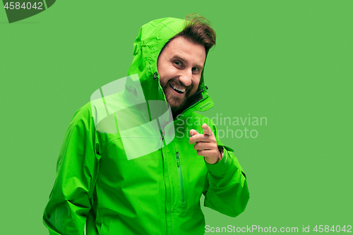 Image of handsome bearded young man looking at camera isolated on green