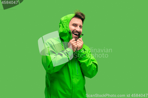 Image of handsome bearded young man looking at camera isolated on green