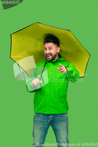 Image of handsome bearded young man holding umbrella and looking at camera isolated on white