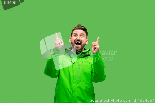 Image of handsome bearded young man looking at camera isolated on green