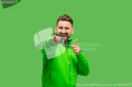 Image of handsome bearded young man looking at camera isolated on green