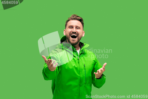 Image of handsome bearded young man looking at camera isolated on green