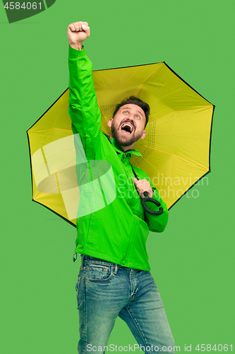 Image of handsome bearded young man holding umbrella and looking at camera isolated on white