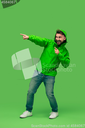 Image of handsome bearded young man looking at camera isolated on green