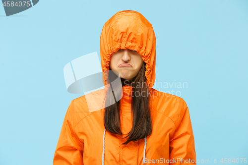 Image of The young girl posing at studio in autumn jacket isolated on blue