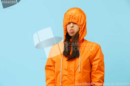 Image of The young girl posing at studio in autumn jacket isolated on blue