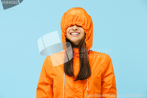 Image of The young surprised couplel posing at studio in autumn jackets isolated on blue