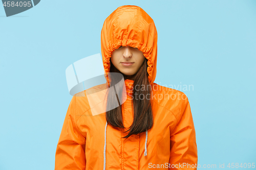 Image of The young girl posing at studio in autumn jacket isolated on blue