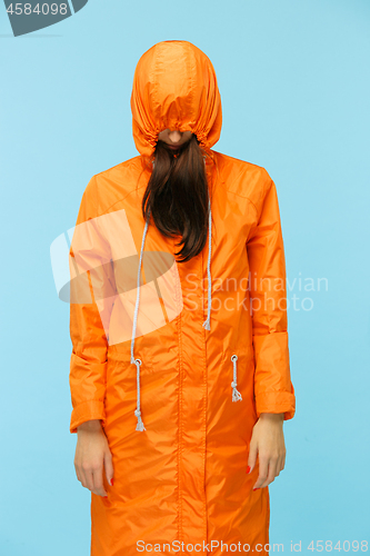 Image of The young girl posing at studio in autumn jacket isolated on blue