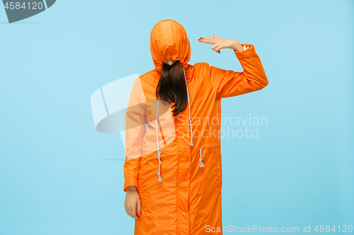 Image of The young girl posing at studio in autumn jacket isolated on blue