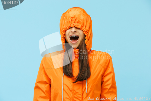 Image of The young surprised couplel posing at studio in autumn jackets isolated on blue