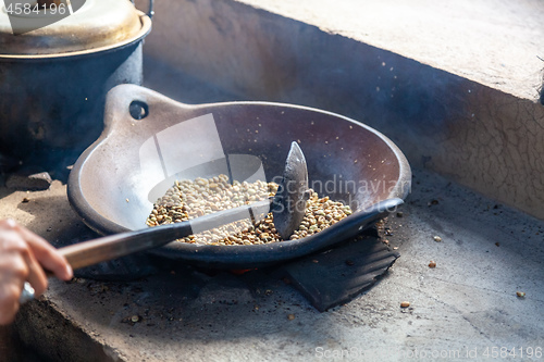 Image of Person roasting fresh coffee beans in a skillet