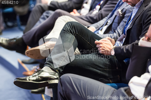 Image of Row of business people sitting at seminar.