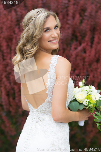 Image of Wedding. Beautiful bride in white dress holding wedding bouquet.