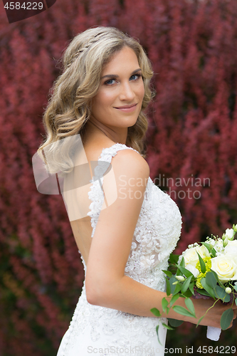 Image of Wedding. Beautiful bride in white dress holding wedding bouquet.